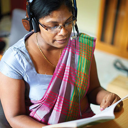 Person Wearing Headphones and Reading a Book