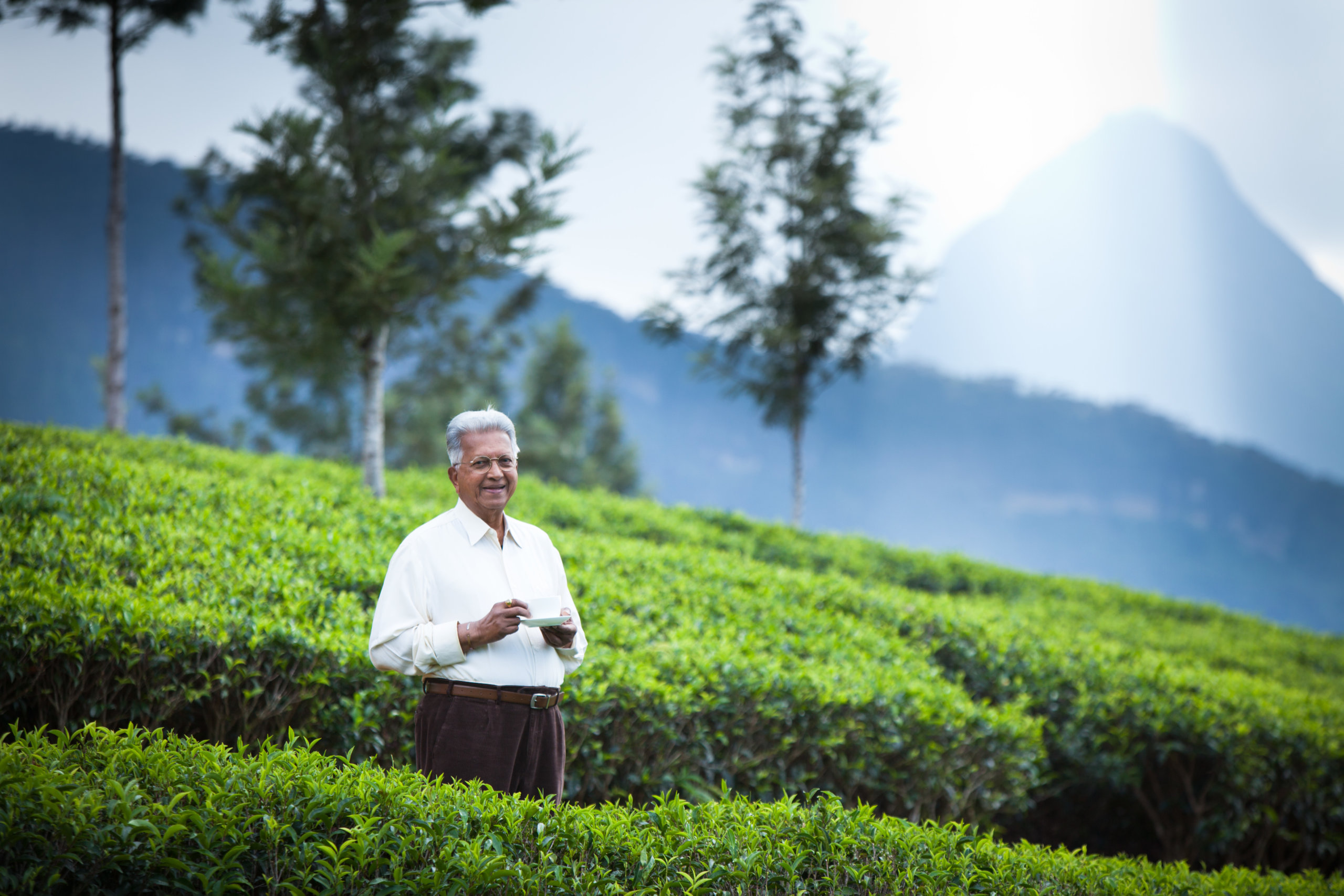 Merril J Fernando MJF with tea cup among tea fields