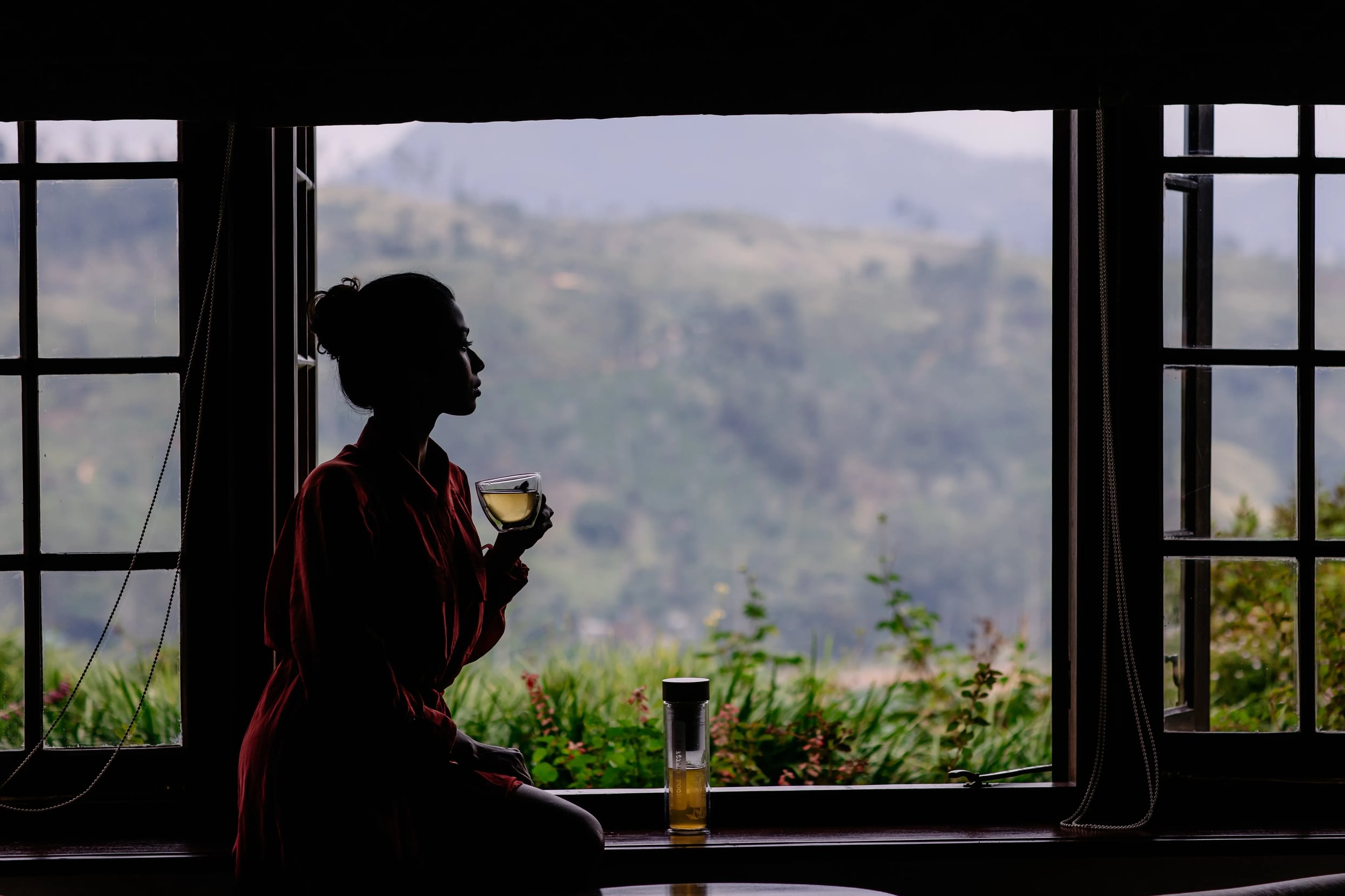 Dilmah Lifestyle Shoot at Ceylon Tea Trails - lady drinks green tea near open window from glass cup 0I1A6670