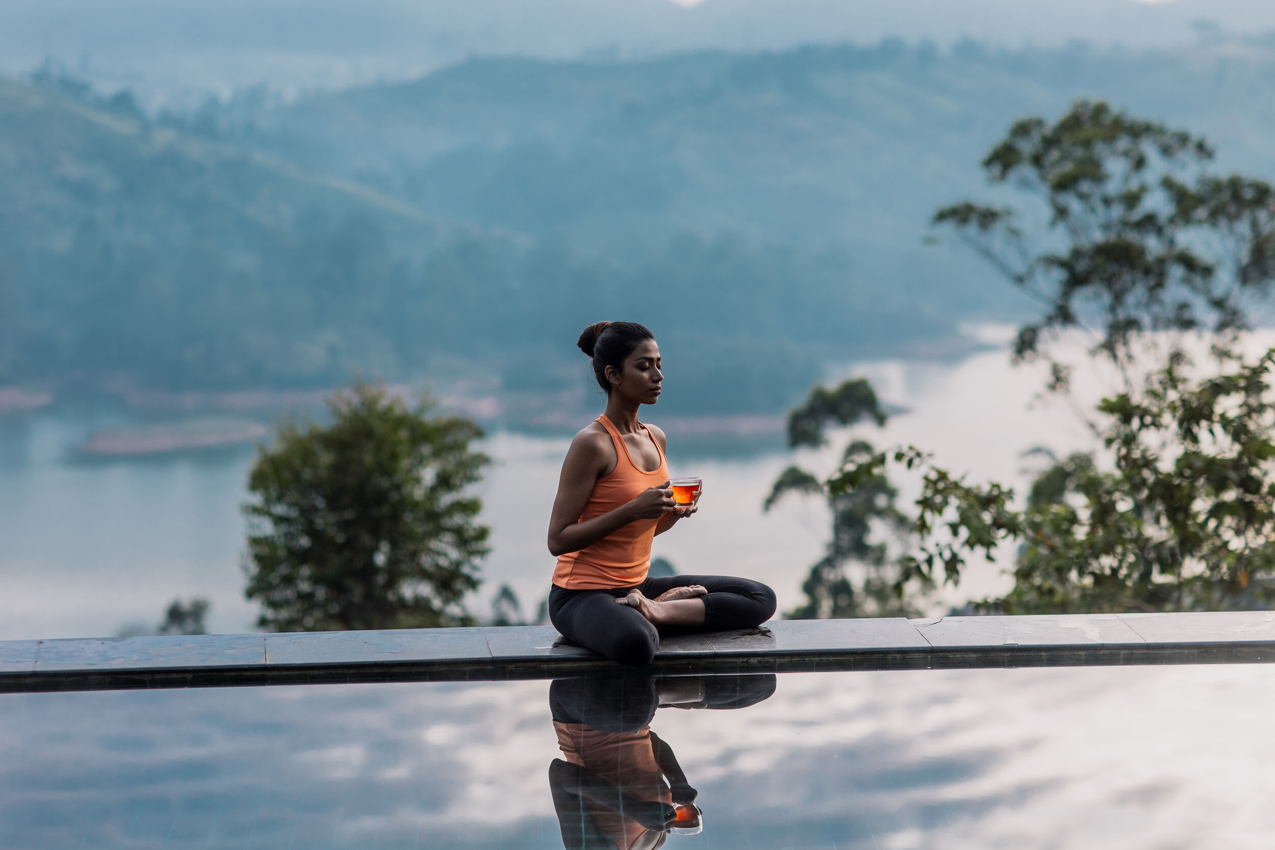 Woman sitting by the pool with a cup of tea
